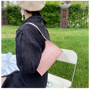 Pink crocodile pattern baguette bag detail showing elegant texture and shoulder strap