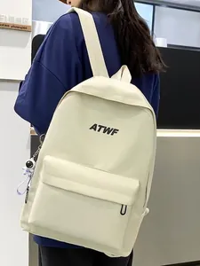 Minimalist cream white backpack with ATWF logo and astronaut charm on a male model
