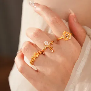 Vintage gold ring set with zircon flowers and woven texture on a hand model