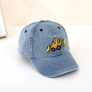 Detailed texture of blue denim kids baseball cap featuring yellow excavator embroidery