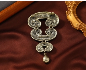 Detail view of vintage gold horn brooch back featuring a secure pin clasp and teardrop charm