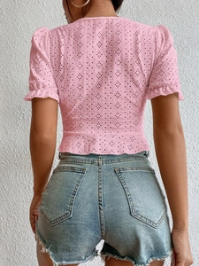 Détail du haut rose en dentelle ajourée avec manches bouffantes et ourlet volanté
