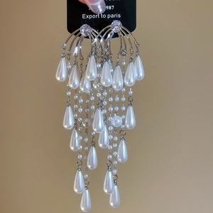 Detail of silver drop tassel earrings featuring sparkling zircon and white pearls