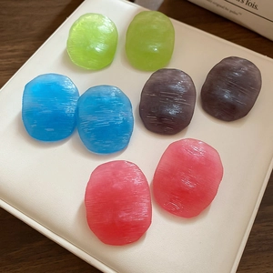 Macro view of textured oval resin earring components in four assorted colors on a tray
