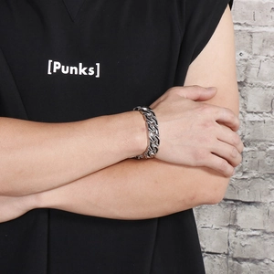 Detail of silver punk chain bracelet with black stripes on male model wrist