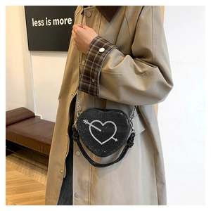Dettaglio di una borsa a tracolla a cuore con strass scintillanti e tracolla a catena