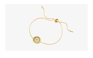 Detail of adjustable gold snake chain bracelet featuring a black and white daisy pendant