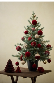 Detail of red flocked and gold glitter ornaments on a mini potted Christmas tree