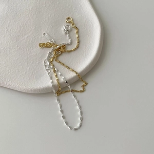 Detailed view of minimalist S925 sterling silver square link bracelets on a stone tray