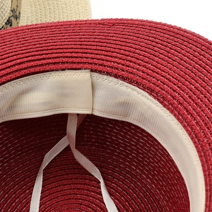 Inside view of red straw sun hat showing white sweatband and adjustable chin strap