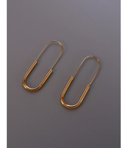 Detail of 18K gold plated stainless steel safety pin earrings on a dark grey surface