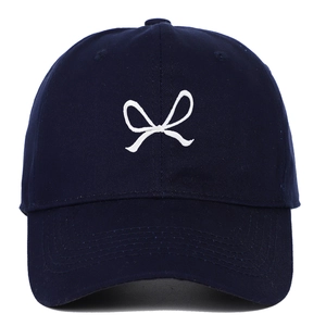 Navy blue cotton baseball cap with white bow ribbon embroidery shown on white background