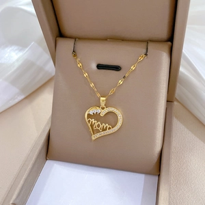 Macro detail of golden heart necklace with Mom lettering and pavé cubic zirconia