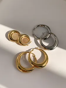 Details von klobigen Gold- und Silber-Creolen in drei Größen mit polierter Oberfläche