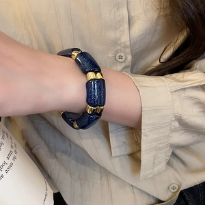 Detail of blue shimmering beads and gold metal spacers on a chic wrist bracelet