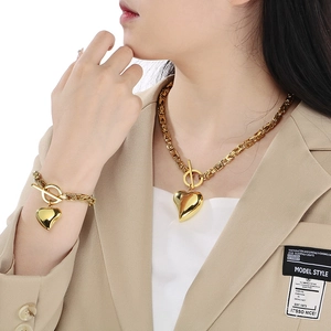 Golden titanium steel jewelry set with heart pendant and OT buckle on elegant model