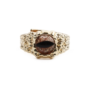 Macro detail of golden eye ring featuring realistic pupil texture and rock surface