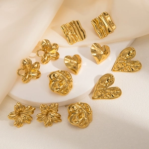 Detailed view of vintage gold geometric heart and floral earrings on silk background