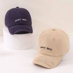 Detailed close-up of distressed brim with embroidered patch on cotton baseball cap