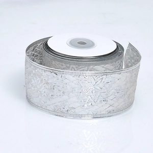 Close-up of sparkling silver lace ribbon roll with metallic floral pattern for Christmas