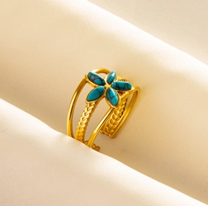 Macro detail of bohemian 304 stainless steel open ring with blue stone and gold floral texture