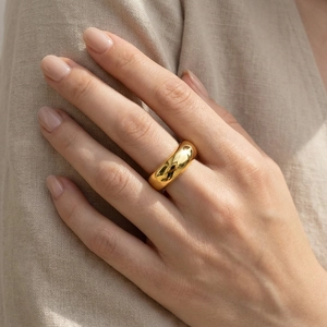 Close-up of polished 18k gold plated wide band ring on model for a minimalist style