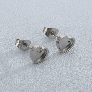316L stainless steel heart-shaped stud earring bases for DIY jewelry making on blue background