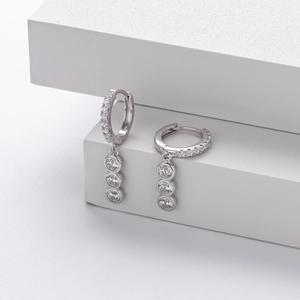 Detail of S925 sterling silver hoop earrings featuring sparkling triple cubic zirconia stones