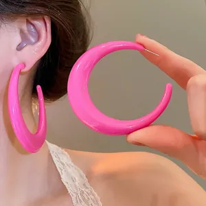 Minimalist peach pink C-shape hoop earrings with a glossy finish and retro dopamine style