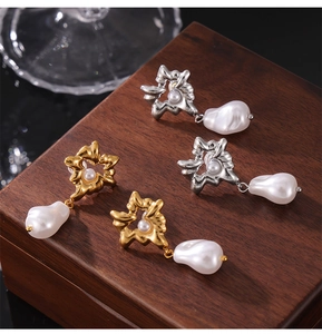 Detailed shot of retro gold and silver heart earrings with pearls on a wooden box