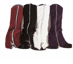 Detail of knitted leg warmers featuring metal zippers in wine red, black, white, and purple