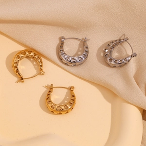 Detailed close-up of 18K gold and silver U-shaped hoop earrings with hollow heart pattern