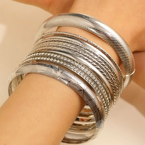 Detail of silver bohemian bangle set with textured patterns and rhinestone accents