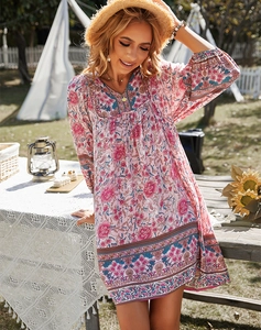 Vue détaillée d'une robe bohème rose à col en V et imprimé floral portée par un modèle