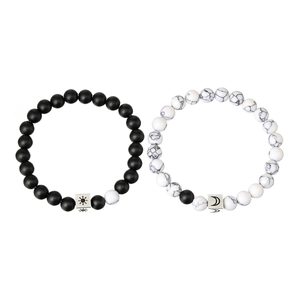 Detail of sun and moon engraved charms on matte black and white marble bead bracelets