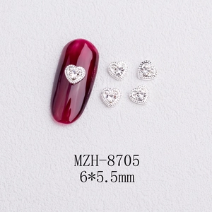 Macro detail of heart-shaped nail charms silver alloy with rhinestones size 6x5.5mm