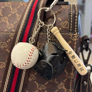 Detailed shot of mini baseball bat glove and ball charms on a keychain accessory