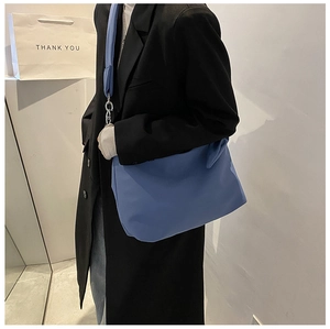 Blue large capacity messenger bag styled with a blazer and casual denim jeans
