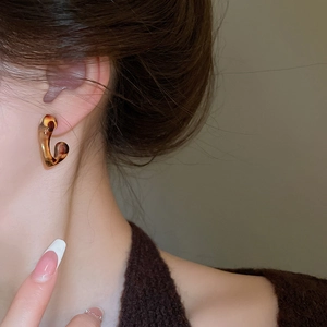 Close-up of elegant amber resin earrings with leopard print design on a female model