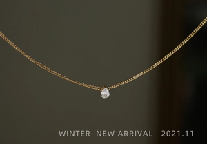 Close-up of matte gold 18K plated curb chain with a pear-cut zircon teardrop pendant