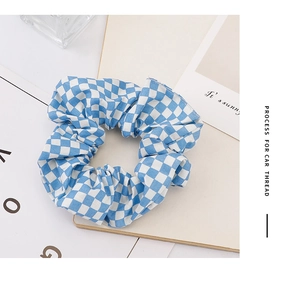 Detail of blue and white checkered scrunchie showing fabric texture and pleats