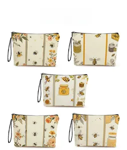 Collection of zip cosmetic bags with yellow bee, flower and honey jar prints