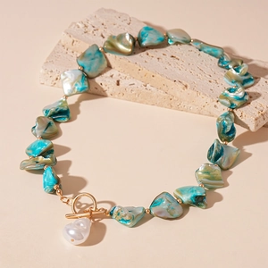Dettaglio della collana di perline verde acqua con chiusura a T e perla barocca