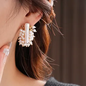 Boucles d'oreilles perles irrégulières avec base dorée et perles blanches de près