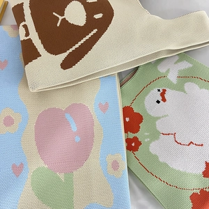 Detail of knitted tote bags featuring cute bear, tulip and duck patterns in pastel tones