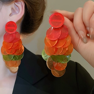 Detail of colorful tiered round resin earrings showing translucent layered textures
