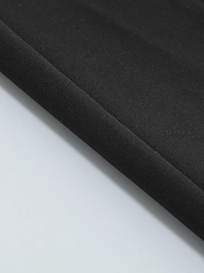 Macro shot of black knitted fabric texture showing intricate woven details and layers
