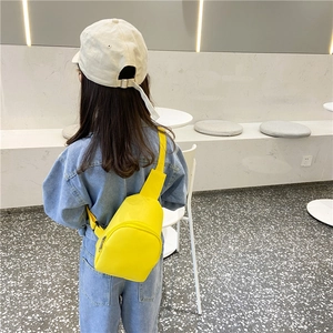Toddler girl bright yellow PU leather crossbody bag worn over light blue denim outfit