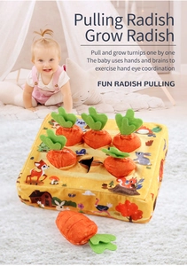 Detail of infant playing with plush carrot toy set to exercise hand-eye coordination
