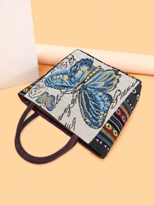 Knitted tote bag with blue butterfly pattern and striped sides in a top view shot